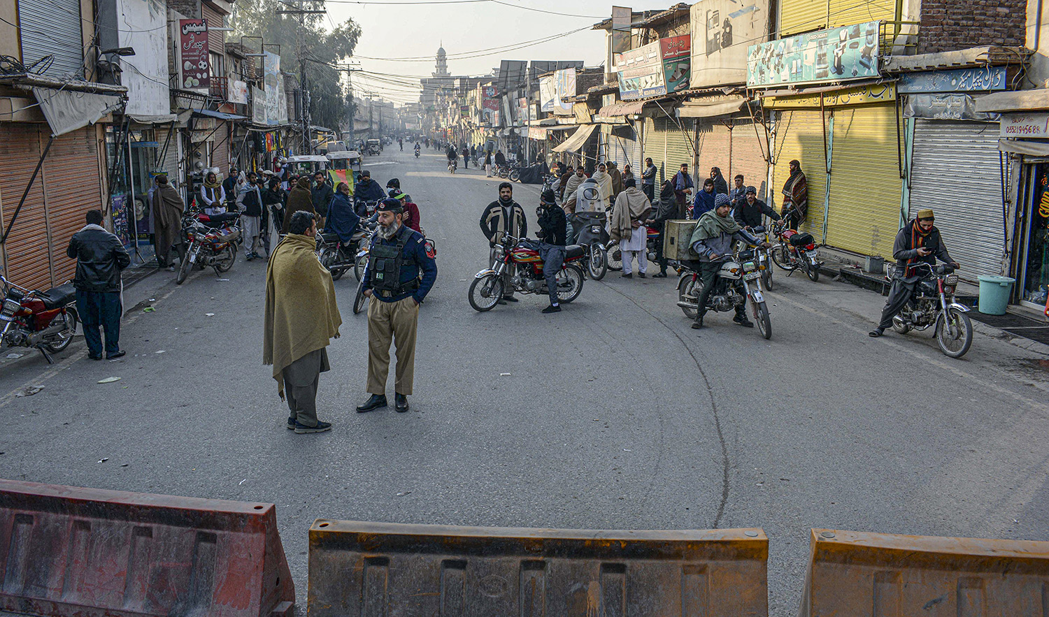 Security officials stand guard on a blocked road leading to a counter-terrorism center where several Pakistani Taliban detainees have taken police officers and others hostage inside the compound, in Bannu district of Pakistan's Khyber Pakhtunkhwa province, on December 19, 2022. (AP)