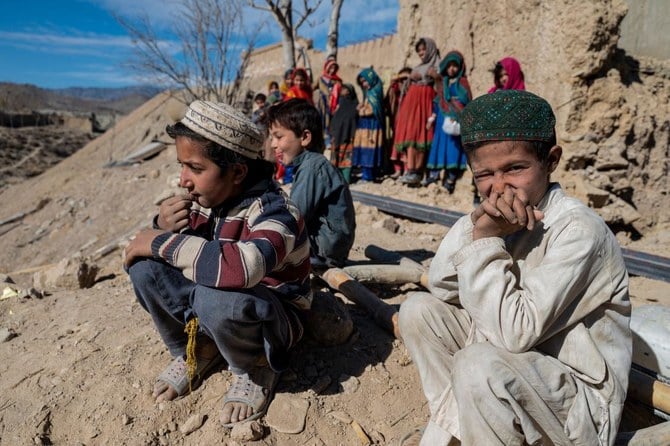 Afghan boys sit outside newly built houses constructed by the United Nations refugee agency (UNHCR) in Barmal district, Paktika province. (AFP)
