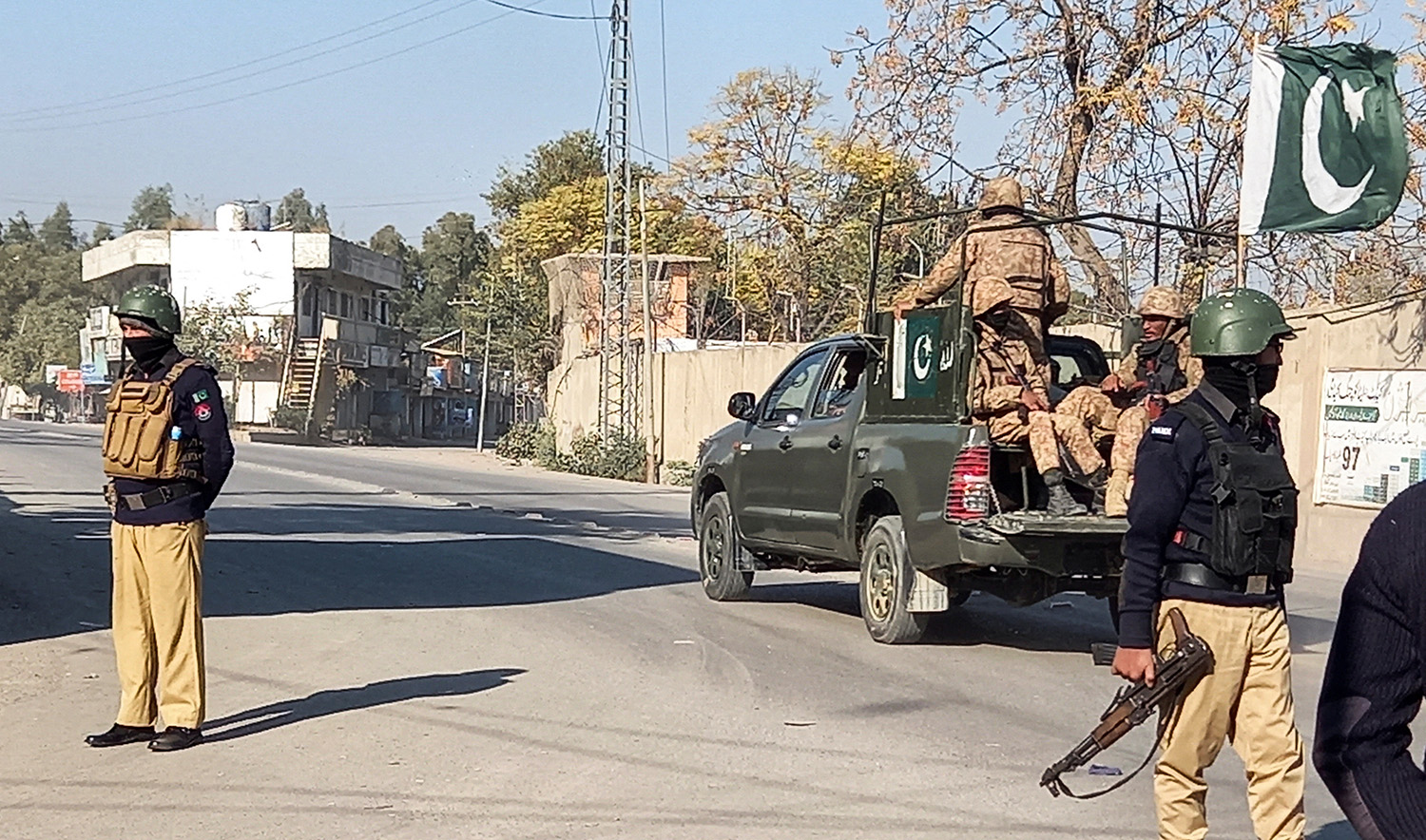 An army vehicle patrols, past police officers stand guard along a road, near cantonment area in Bannu, Pakistan on December 21, 2022. (REUTERS)