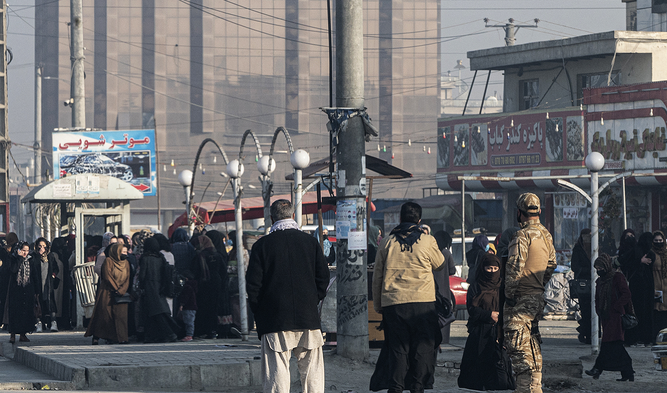 Afghan female university students stop by Taliban security personnel stand next to a private university in Kabul on December 21, 2022. (Photo courtesy: AFP)