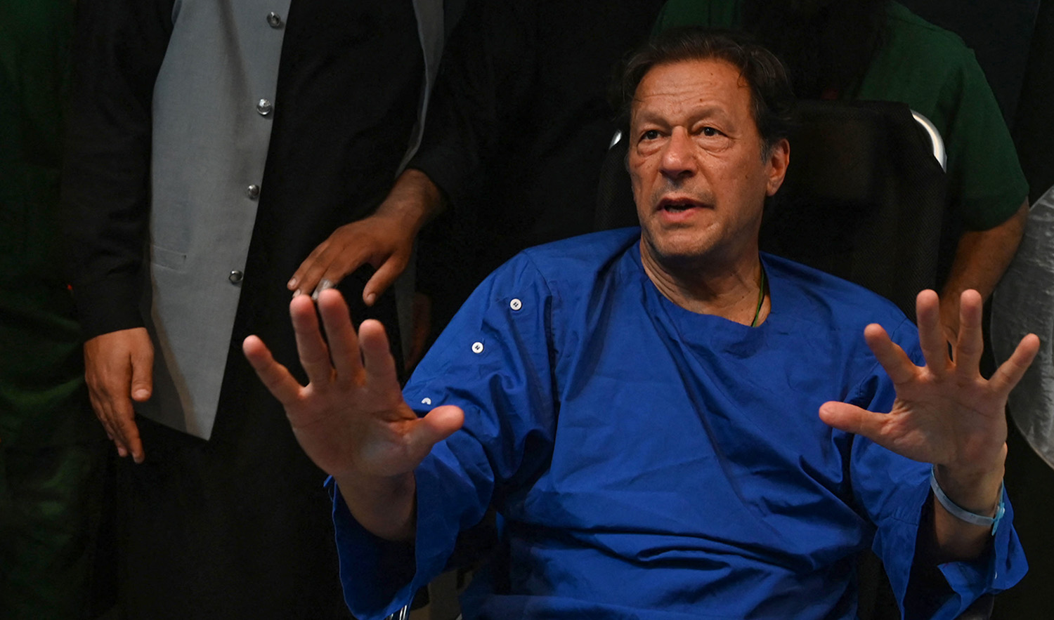 Pakistani paramedics move Pakistan's former prime minister Imran Khan as he sits in a wheelchair, after speaking to media representatives at a hospital in Lahore on November 4, 2022. (AFP/File)