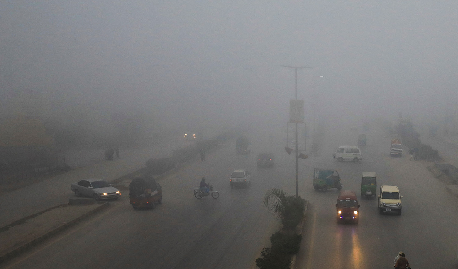Vehicles move amid fog during morning hours in Peshawar, Pakistan on December 22, 2022. (REUTERS)