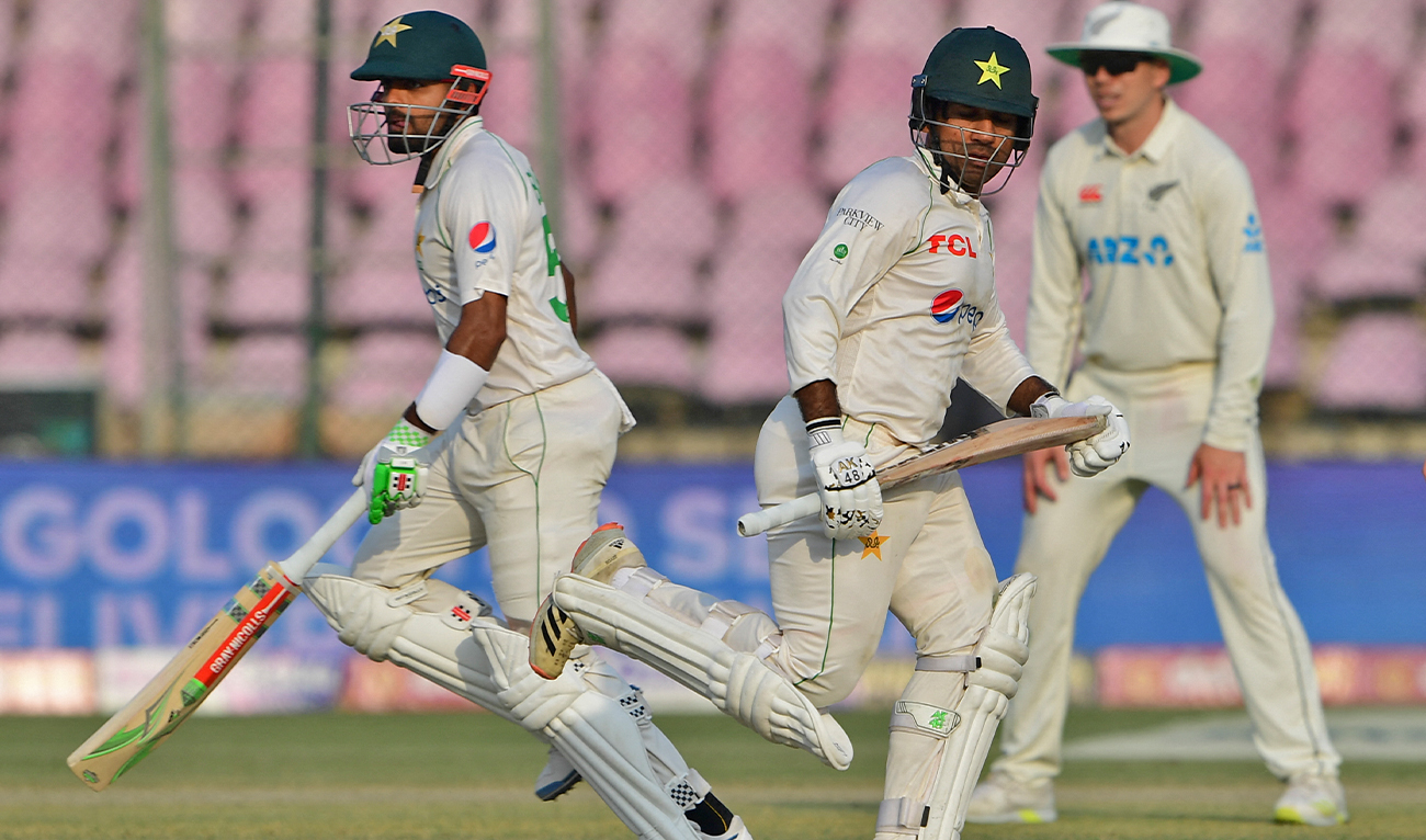Pakistan's Sarfaraz Ahmed (2R) and captain Babar Azam run between the wickets during the first day of the first cricket Test match between Pakistan and New Zealand at the National Stadium in Karachi, Pakistan, on December 26, 2022. (AFP)