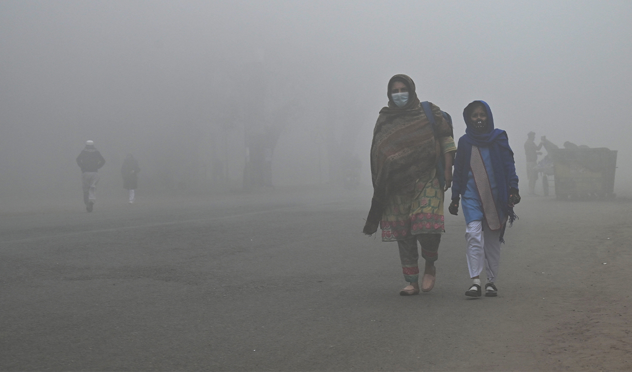 A student walks with her mother to school amid foggy weather in Lahore, Pakistan on December 21, 2022. (AFP)