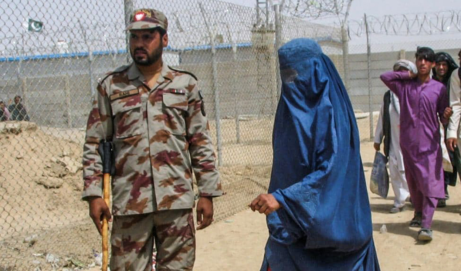 An Afghan woman clad in a burqa walks past Pakistan's paramilitary soldier, as she enters Pakistan via Friendship Gate crossing point at the Pakistan-Afghanistan border town of Chaman, Pakistan on August 17, 2021. (REUTERS/File)