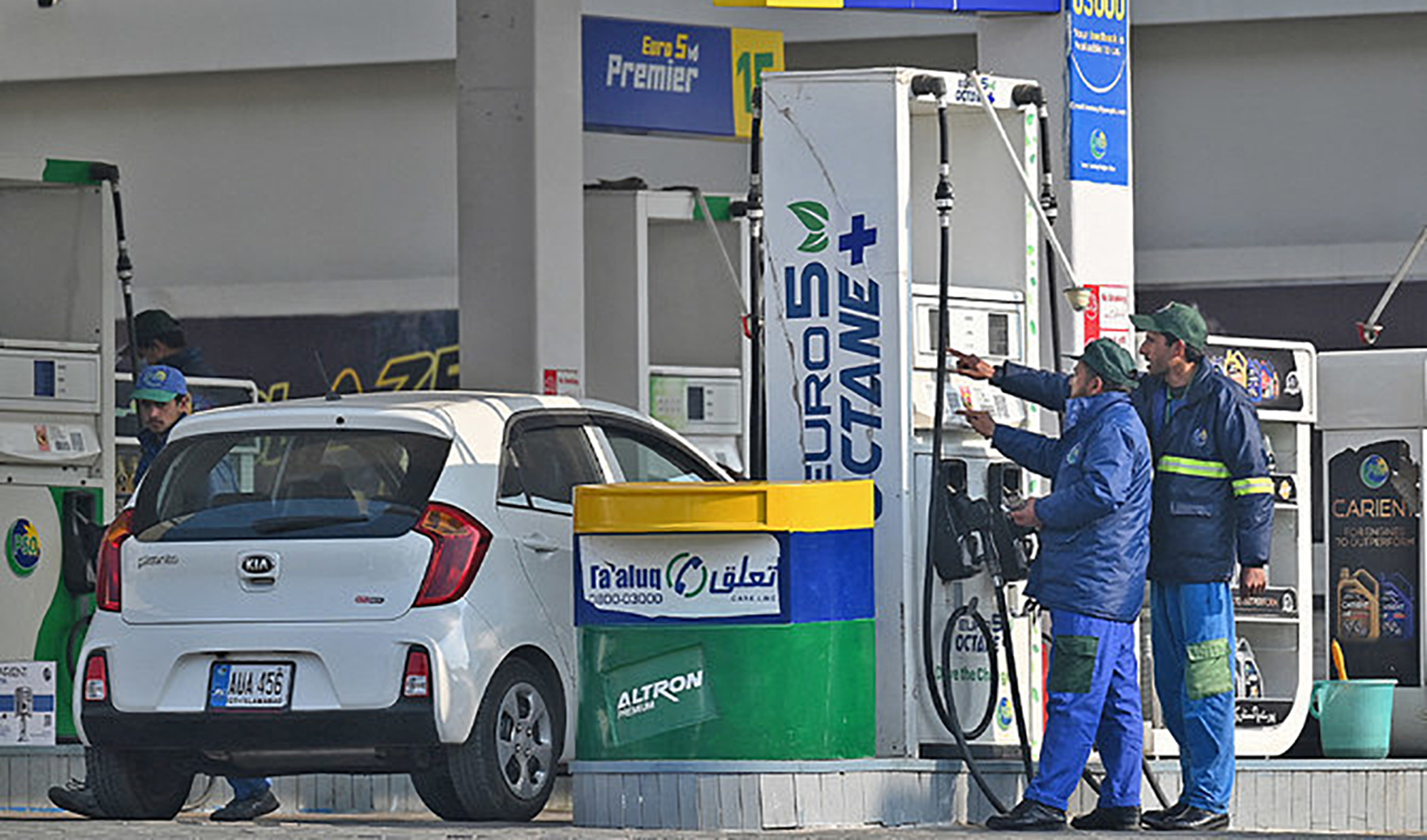 Employees at a fuel station attend to their customers in Islamabad, Pakistan, on February 16, 2022. (AFP/File)