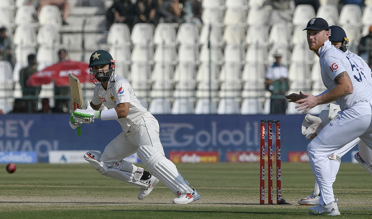 Pakistan's Mohammad Rizwan (L) plays a shot as England's captain Ben Stokes (R) watches during the third day of the second cricket Test match between Pakistan and England at the Multan Cricket Stadium in Multan on December 11, 2022. (Photo courtesy: AFP)