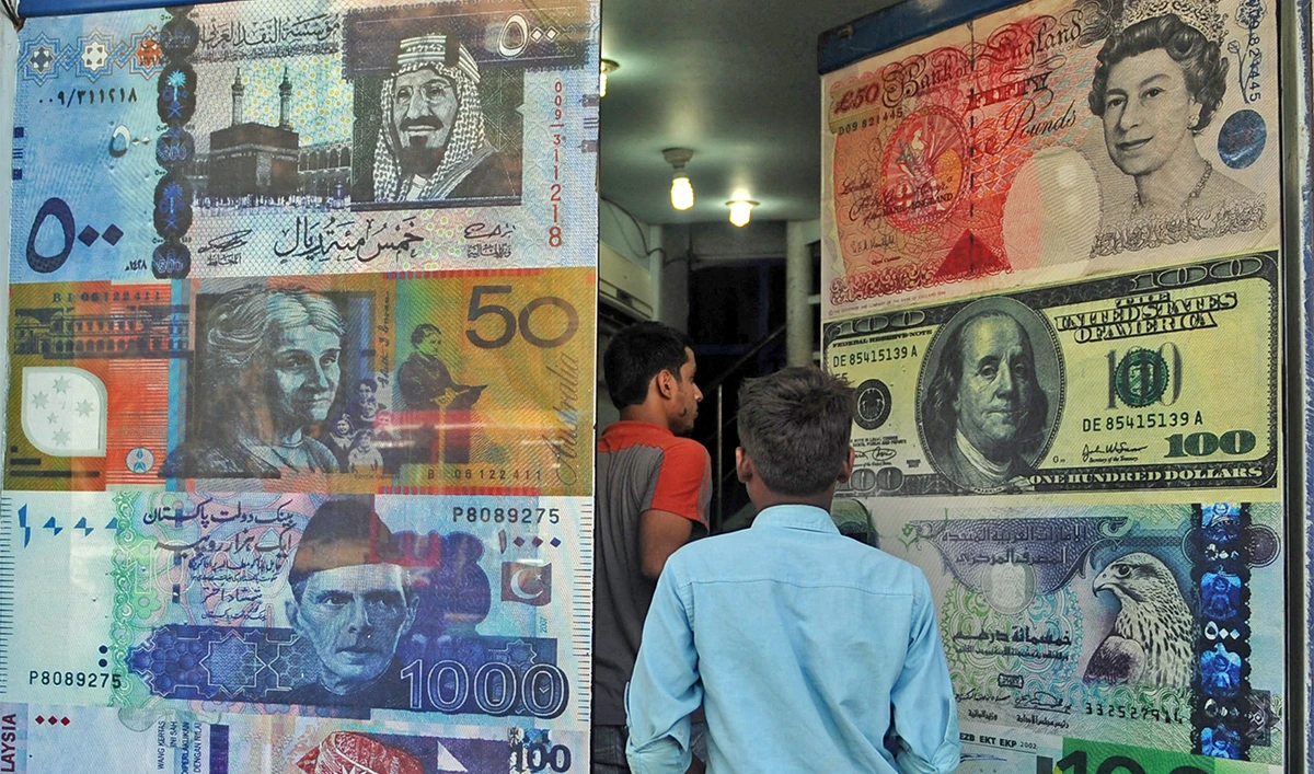 Pakistani customers enter a foreign currency exchange shop in Karachi, Pakistan, on October 14, 2010. (AFP/File)