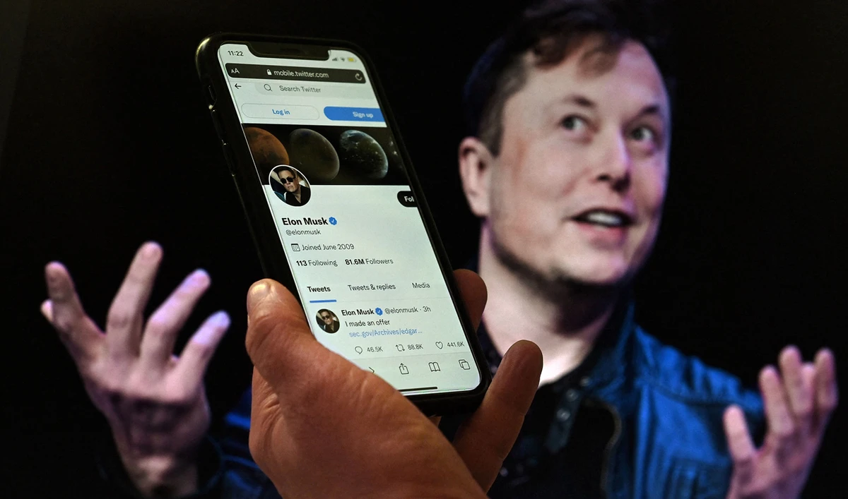 In this file photo taken on April 14, 2022 a phone screen displays the Twitter account of Elon Musk with a photo of him shown in the background, in Washington, DC. (Photo courtesy: AFP)
