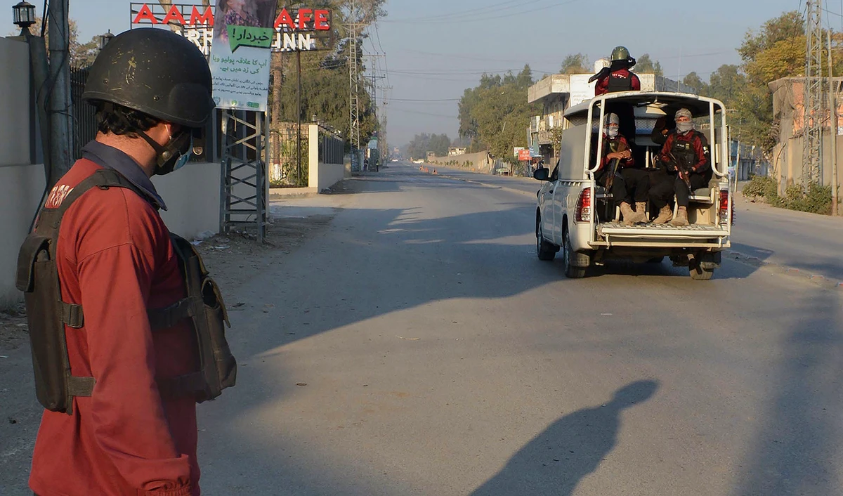 Security officials patrol on a blocked road leading to a counter-terrorism center, where several Pakistani Taliban detainees have taken police and others hostage inside the compound, in Bannu district of Pakistan's Khyber Pakhtunkhwa province on December 19, 2022. (AP)