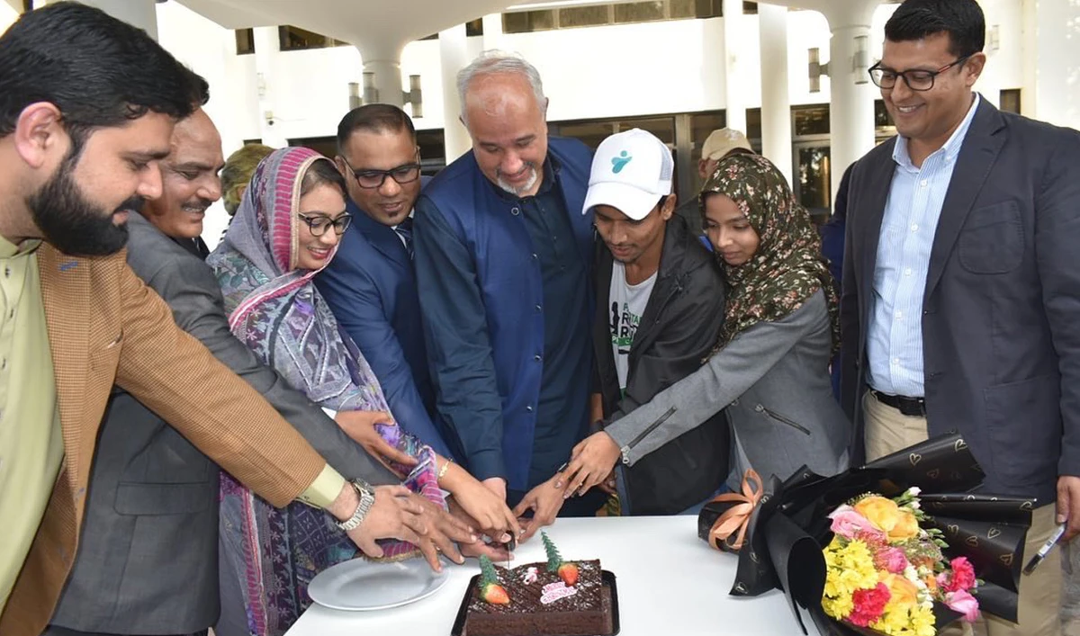 This handout photograph taken on December 23, 2022 and released by Pakistan Embassy in UAE shows the country's Ambassador Faisal Niaz Tirmiz (c) cutting a Christmas cake with the Pakistani Christian community residing in Abu Dhabi. (Photo courtesy: Twitter/PakinUAE)