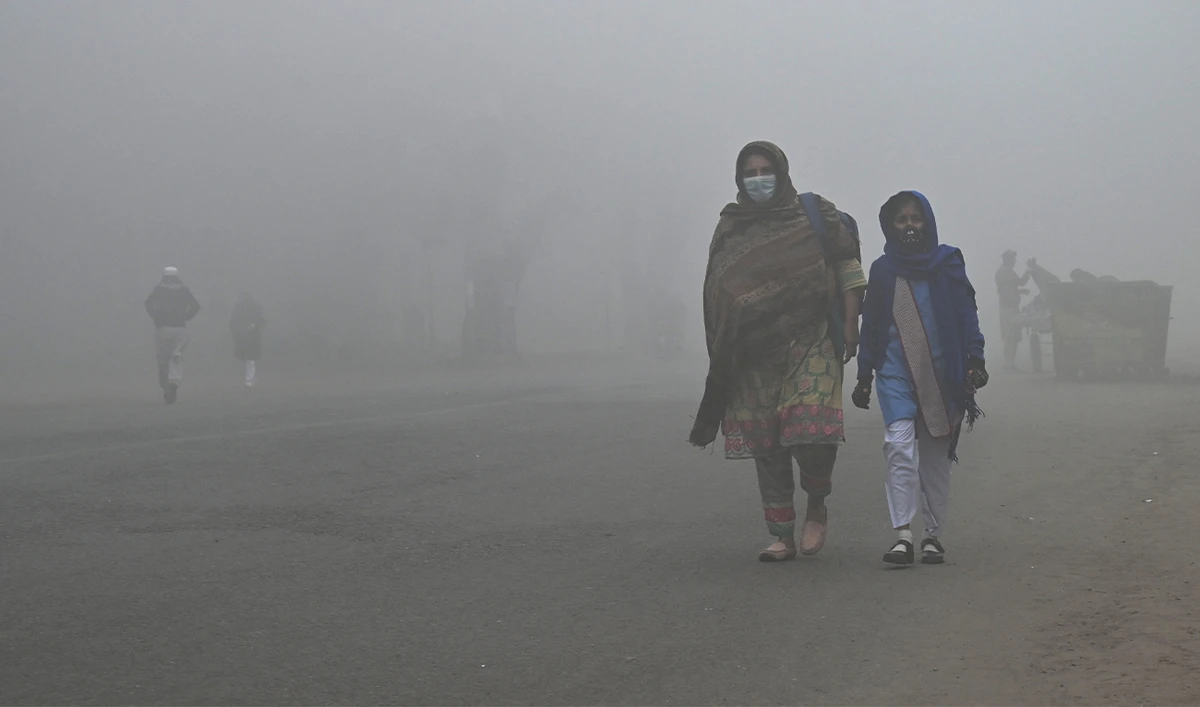 A student walks with her mother to school amid foggy weather in Lahore, Pakistan on December 21, 2022. (AFP)