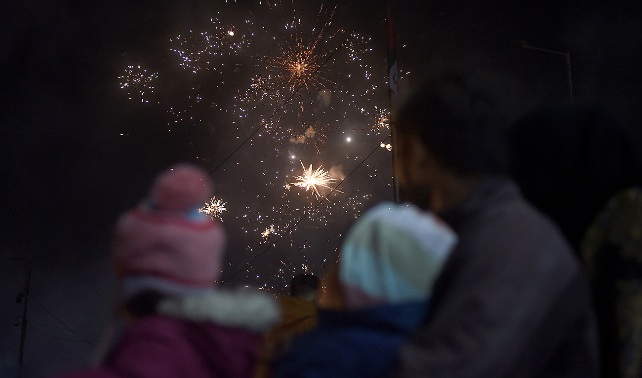 Revelers watch a fireworks show during New Year celebrations in Karachi on early January 1, 2023. (Photo courtesy: AFP)