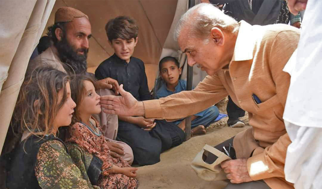 The file photo shows Pakistan Prime Minister Shehbaz Sharif (right) meeting the flood affected families in Balochistan’s Qila Saifullah district on August 1, 2022. (Government of Pakistan)