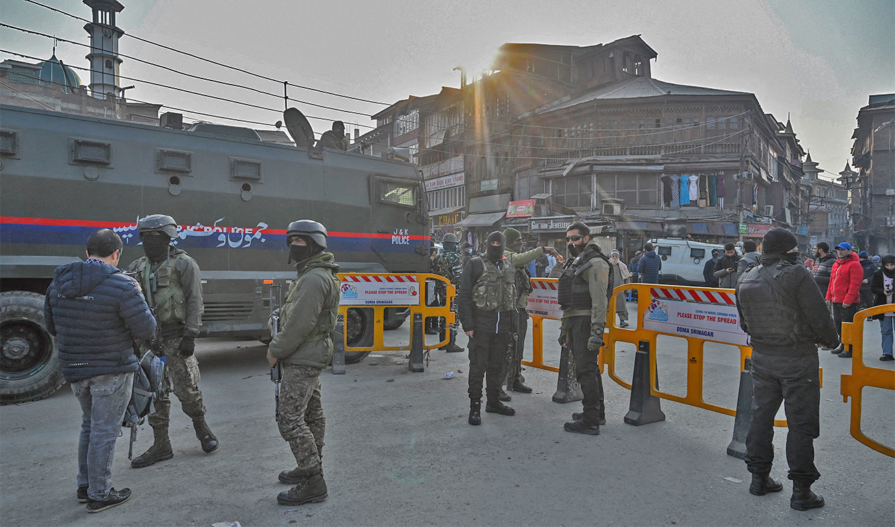 Indian paramilitary troopers search a bag of a pedestrian (L) during a random search operation in Srinagar on January 3, 2023. (AFP)