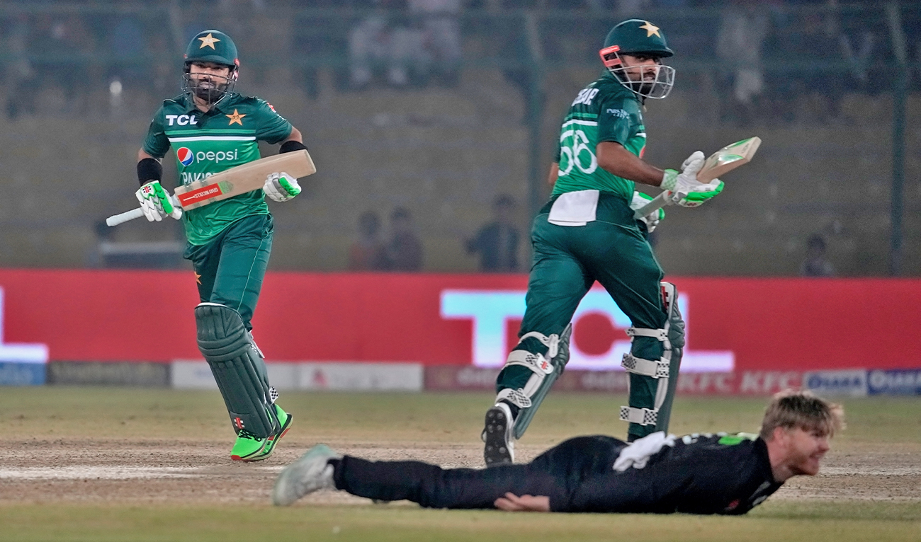 Pakistan's Mohammad Rizwan, left, and Babar Azam, right, take a run as New Zealand's Glenn Phillips dives for fielding during the first one-day international cricket match between Pakistan and New Zealand, in Karachi, Pakistan, on January 9, 2023. (AP/File)