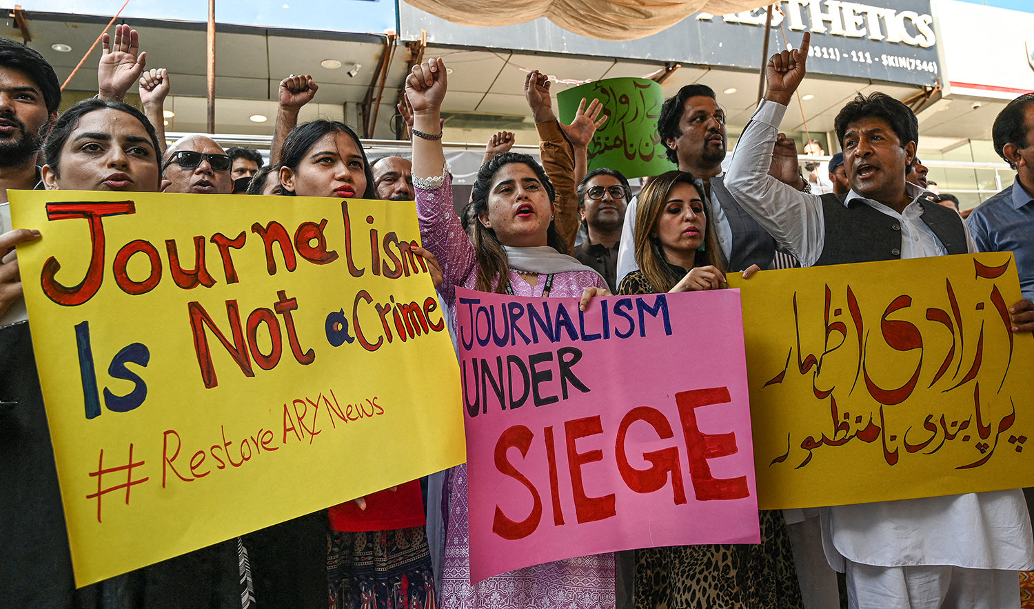 Journalists and employees of ARY News, a private news channel, chant slogans and hold placards during a protest against the channel being taken off air by the government in Islamabad on August 12, 2022. (AFP/File)