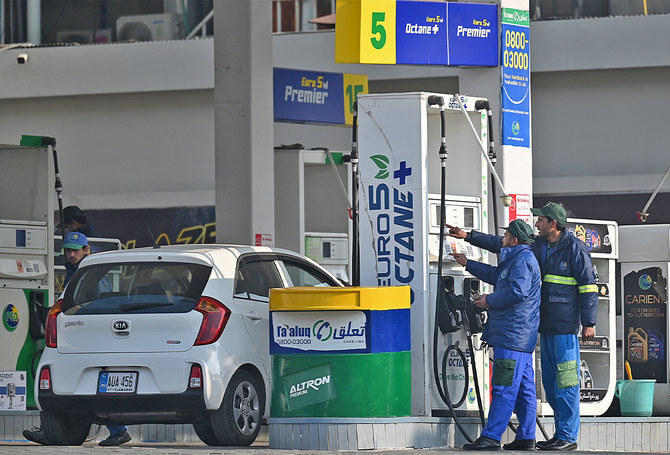 Employees at a fuel station attend to their customers in Islamabad, Pakistan, on February 16, 2022. (AFP/File)