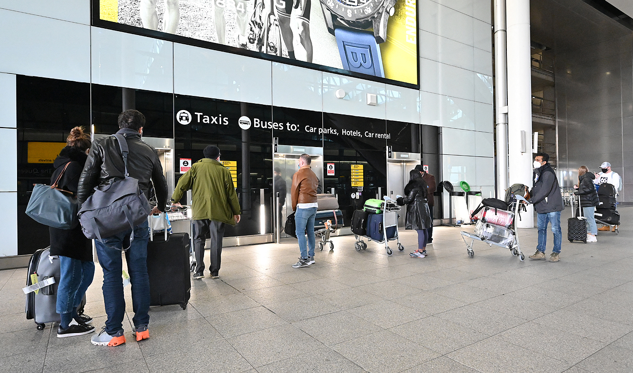 In this file photo taken on February 14, 2021, passengers with luggage wait for the lifts to the car parks and public transport at London Heathrow Airport in west London. (Photo courtesy: AFP/File)