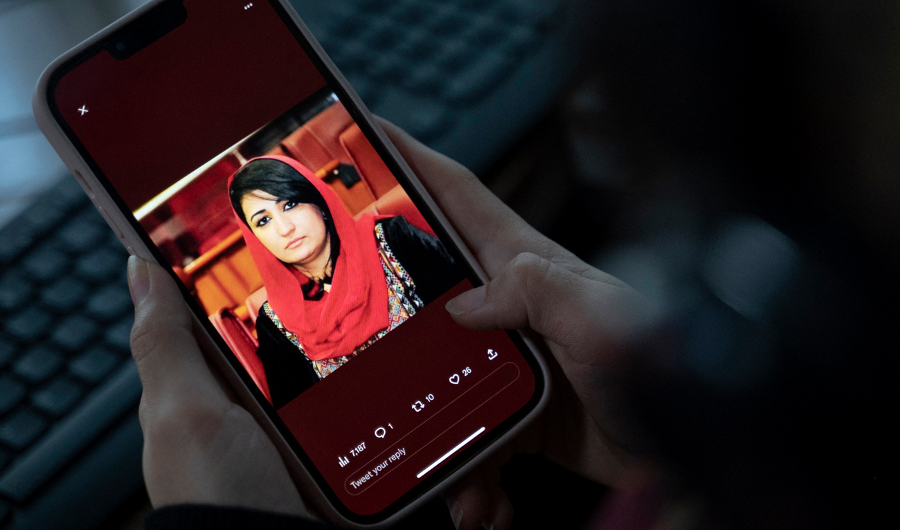A woman looks at a picture of former Afghan lawmaker Mursal Nabizada on her mobile phone, who was shot dead by gunmen last night at her house in Kabul on January 15, 2023. (Photo courtesy: AFP)