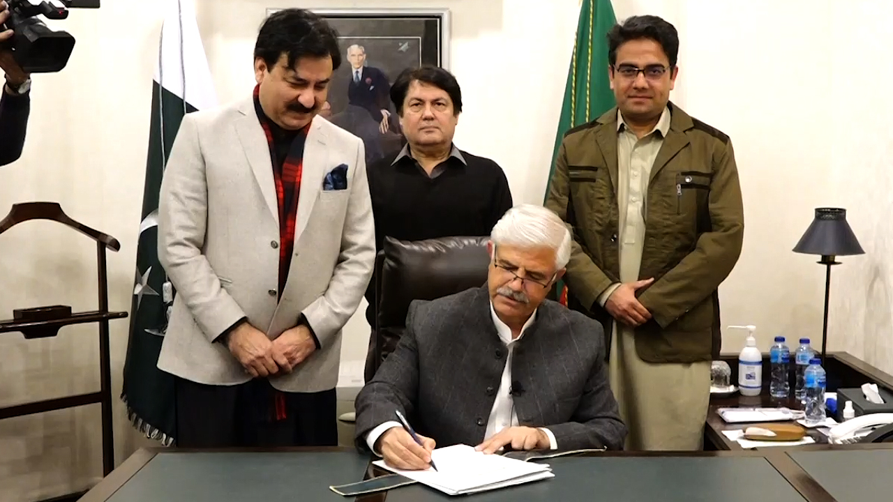 This screengrab shows Khyber Pakhtunkhwa Chief Minister Mahmood Khan while signing the summary for dissolution of the provincial assembly in Peshawar on January 17, 2023. (Courtesy: CM House Khyber Pakhtunkhwa)