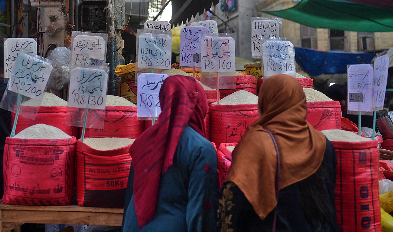 In this picture taken on January 10, 2023, women check rice prices at a main wholesale market in Karachi. (AFP)
