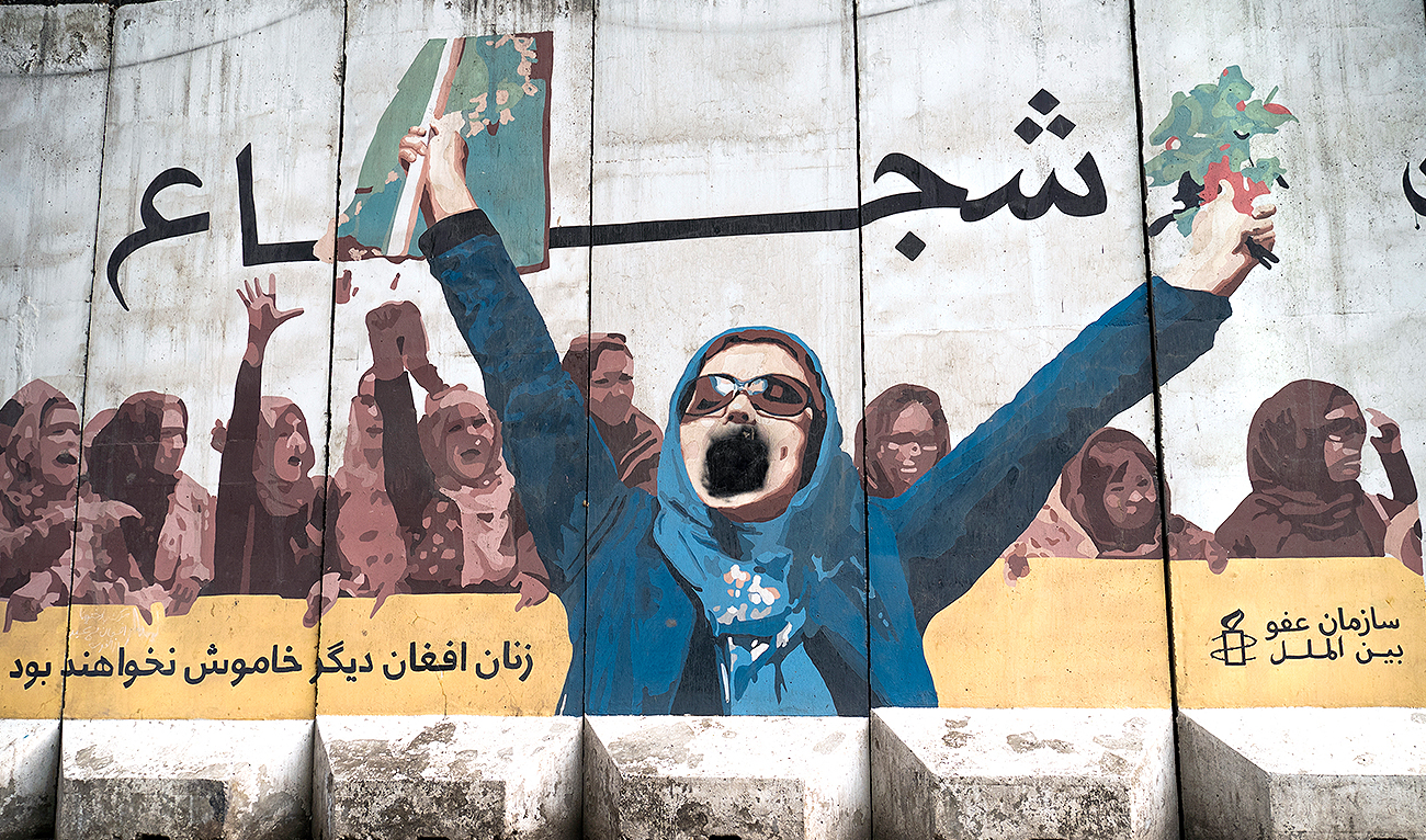 A wall mural of women with a writing "Afghan women will not be silent anymore" is depicted along a street in Kabul on January 10, 2023. (Photo courtesy: AFP)