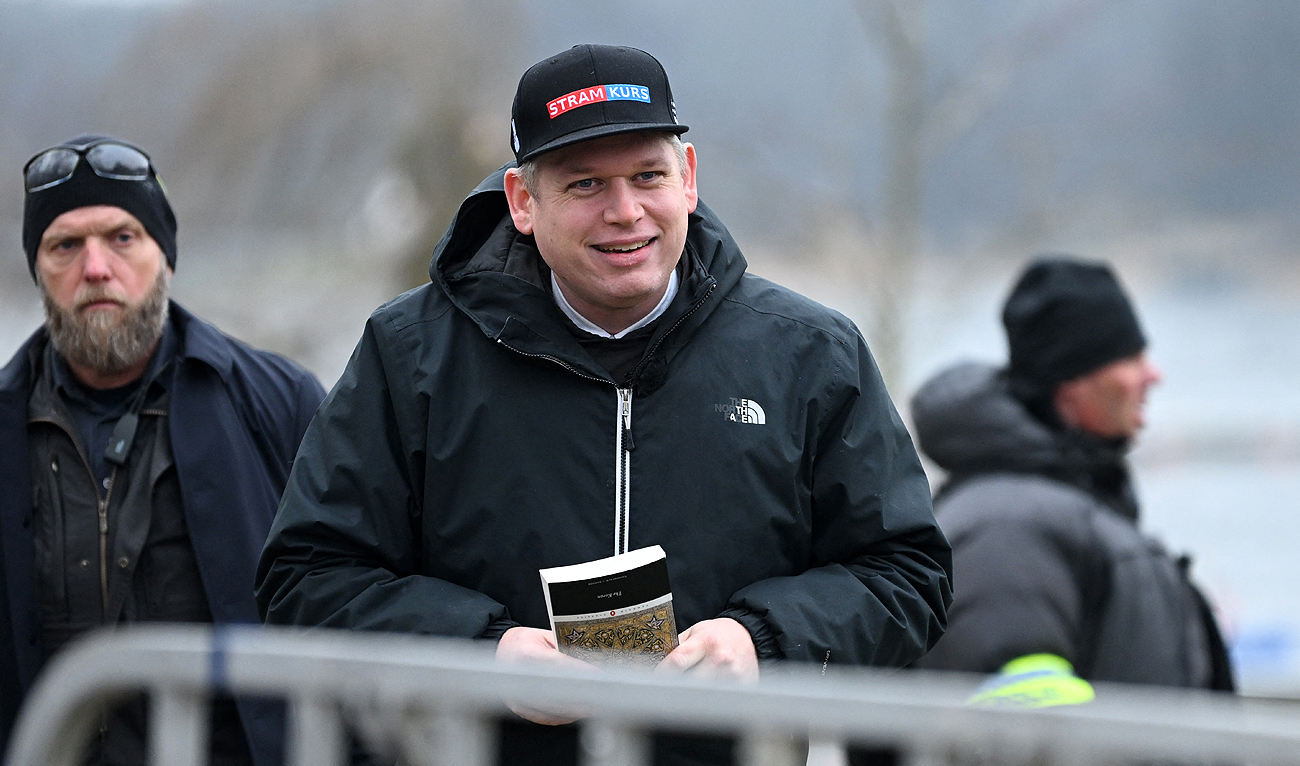 The leader of the far-right Danish political party Stram Kurs, Swedish-Danish politician Rasmus Paludan is pictured while holding an edition of The Quran, the central religious text of Islam, while staging a protest outside the Turkish Embassy in Stockholm, Sweden, on January 21, 2023. (Photo courtesy: AFP)