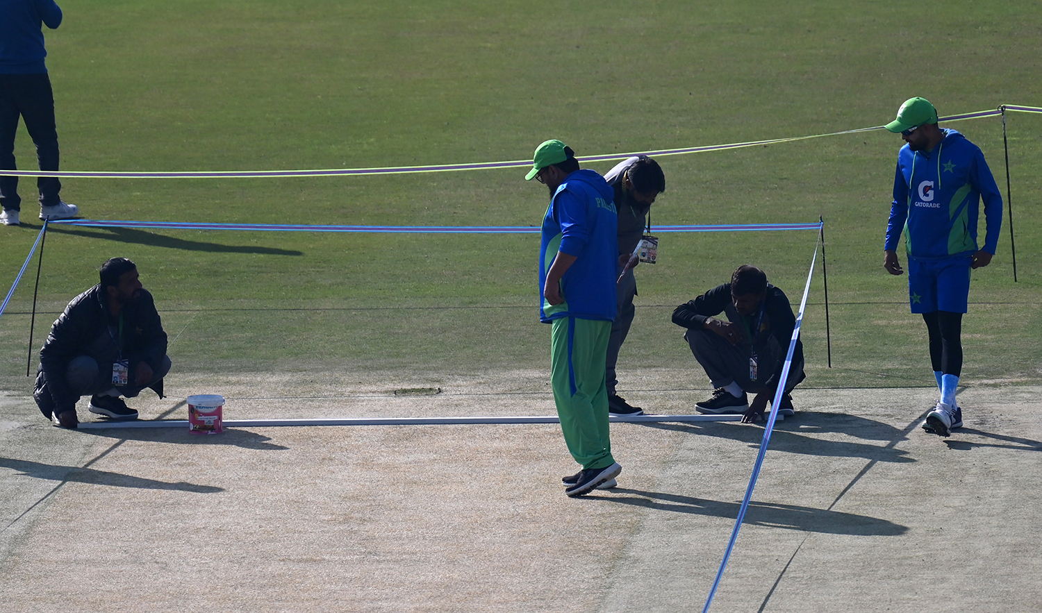 Pakistan's captain Babar Azam, right, and head coach Saqlain Mushtaq, center, inspect the pitch ahead of their first cricket Test match against England, at the Rawalpindi Cricket Stadium in Rawalpindi on November 30, 2022. (AFP/File)