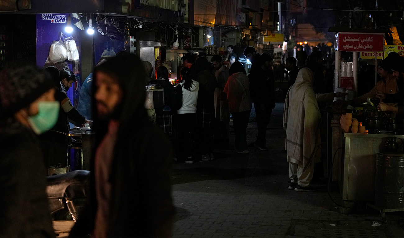 People visit a market, where some shopkeeper are using generators for electricity during a national-wide power breakdown, in Islamabad, Pakistan, on January 23, 2023. (AP)