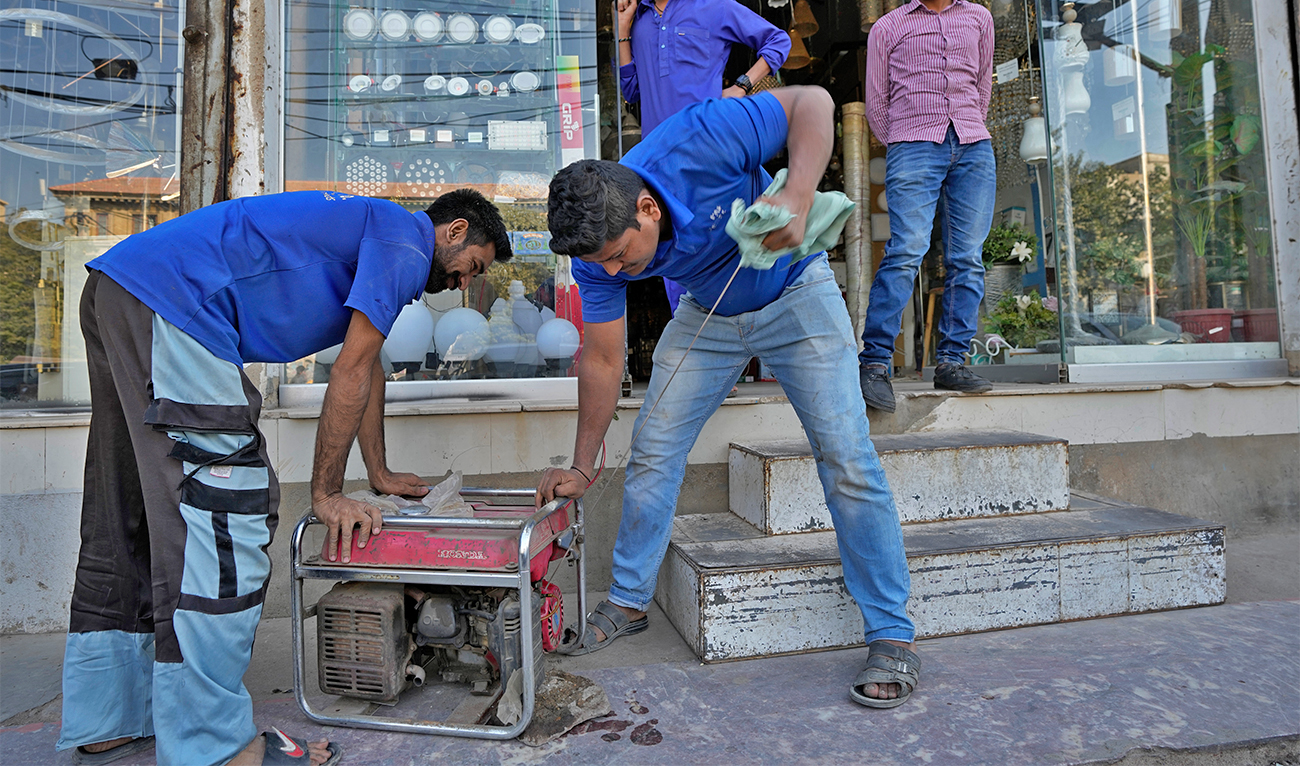 A shopkeeper starts a generator for electricity at a shop following a power breakdown across the country, in Karachi, Pakistan, on January 23, 2023. (AP)