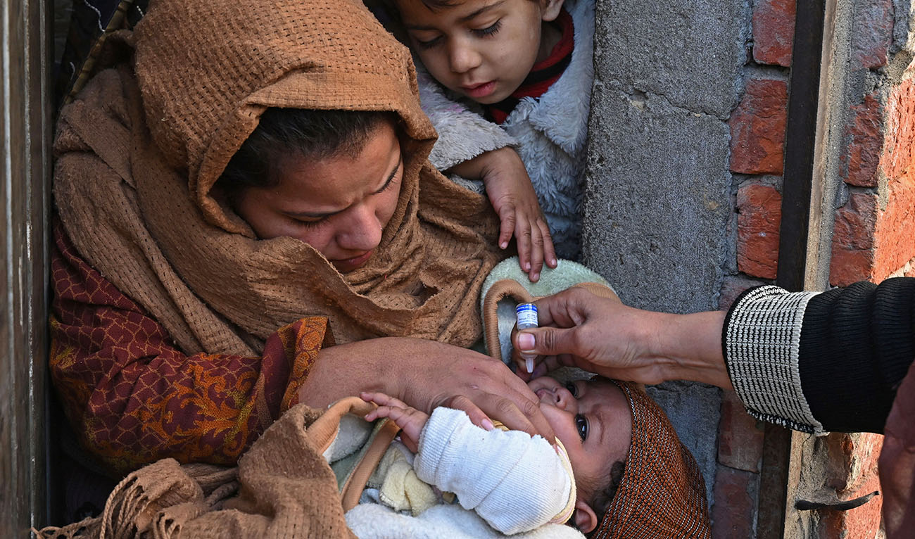 A health worker administers polio vaccine drops to a child during a vaccination campaign in Lahore on January 16, 2023. (AFP/FILE)