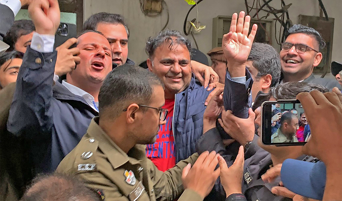 Police officials escort the arrested leader of opposition Pakistan Tehreek-e-Insaf (PTI) party, Fawad Chaudhry (C) to present him before a court in Lahore, Pakistan, on January 25, 2023. (AFP)