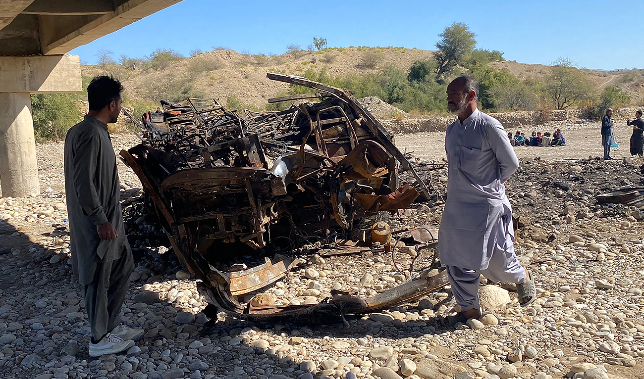 Residents look at the wreckage of a burnt passenger bus in Lasbela district of Pakistan's Balochistan province on January 29, 2023. (Photo courtesy: AFP)