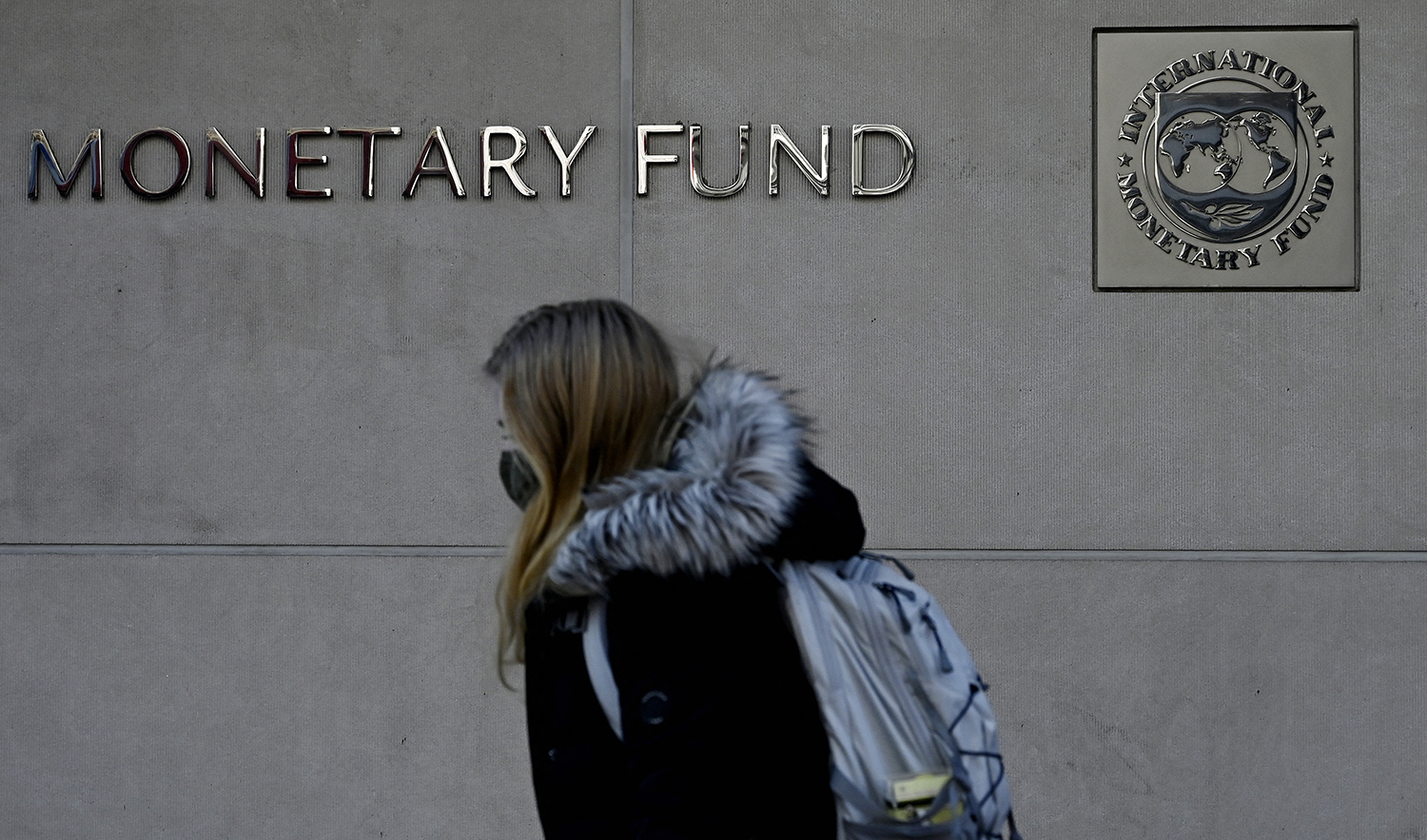 A woman walks past the International Monetary Fund headquarters in Washington, DC, on January 26, 2022. (AFP/File)