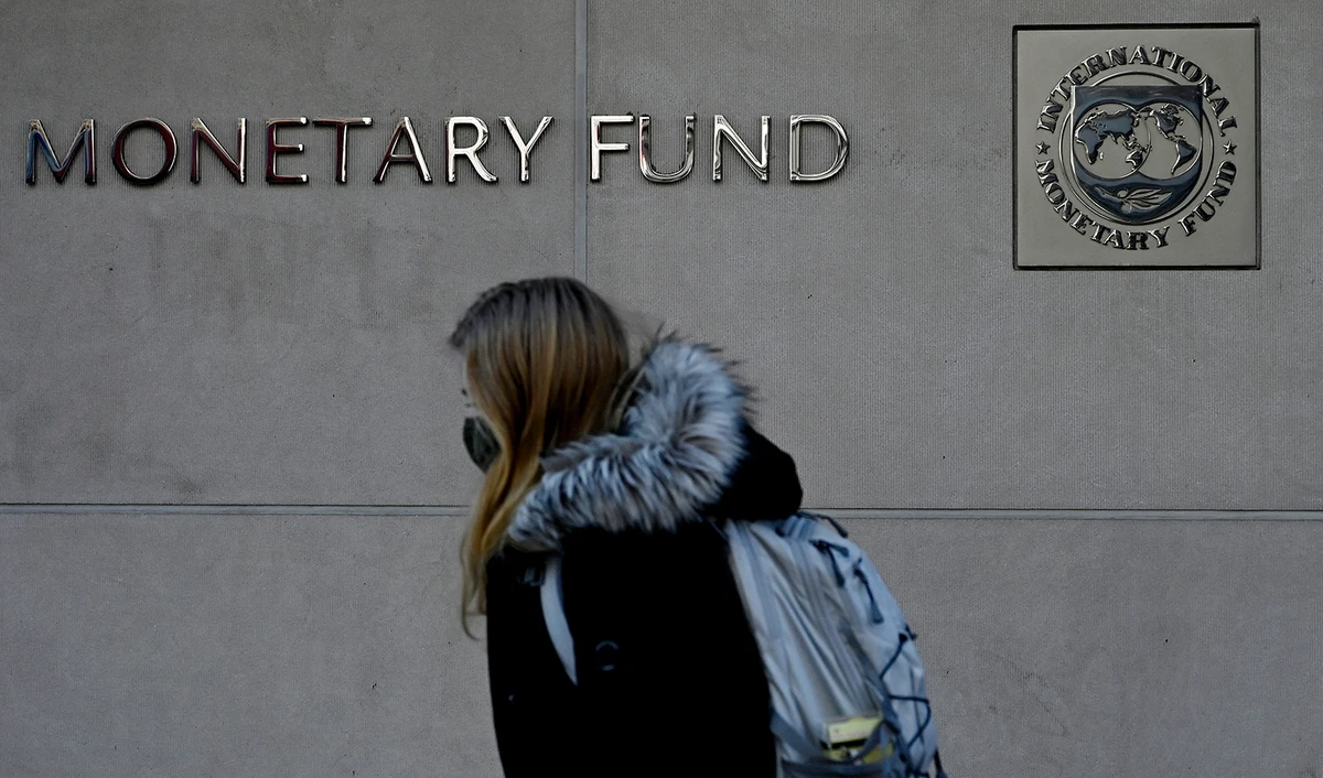 A woman walks past the International Monetary Fund headquarters in Washington, DC, on January 26, 2022. (AFP/File)