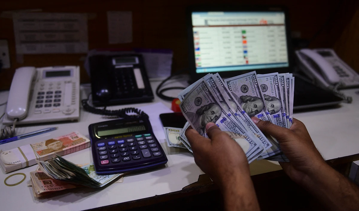 A dealer counts US dollars at a money exchange market in Karachi, Pakistan on January 27, 2023. (AFP)