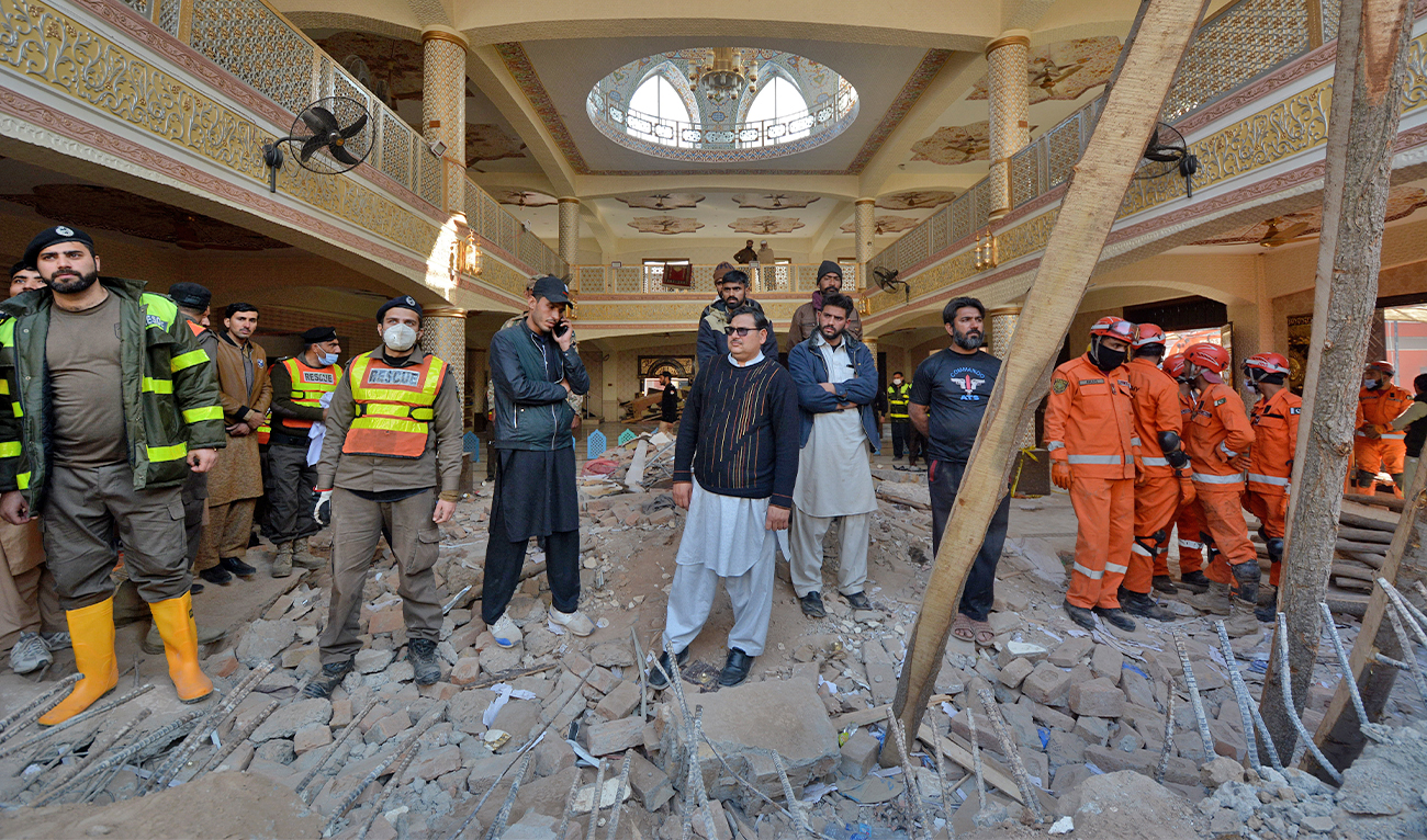 Rescue workers gather as they conduct an operation to clear the rubble and search for bodies at the site of Monday's suicide bombing, in Peshawar, Pakistan, on January 31, 2023. (AP)