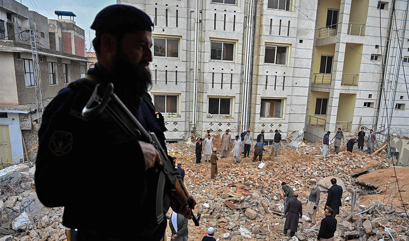 Plain-cloth policemen and labourers remove debris beside a damaged mosque following January's 30 suicide blast inside the police headquarters in Peshawar, Pakistan, on February 1, 2023. (AFP)