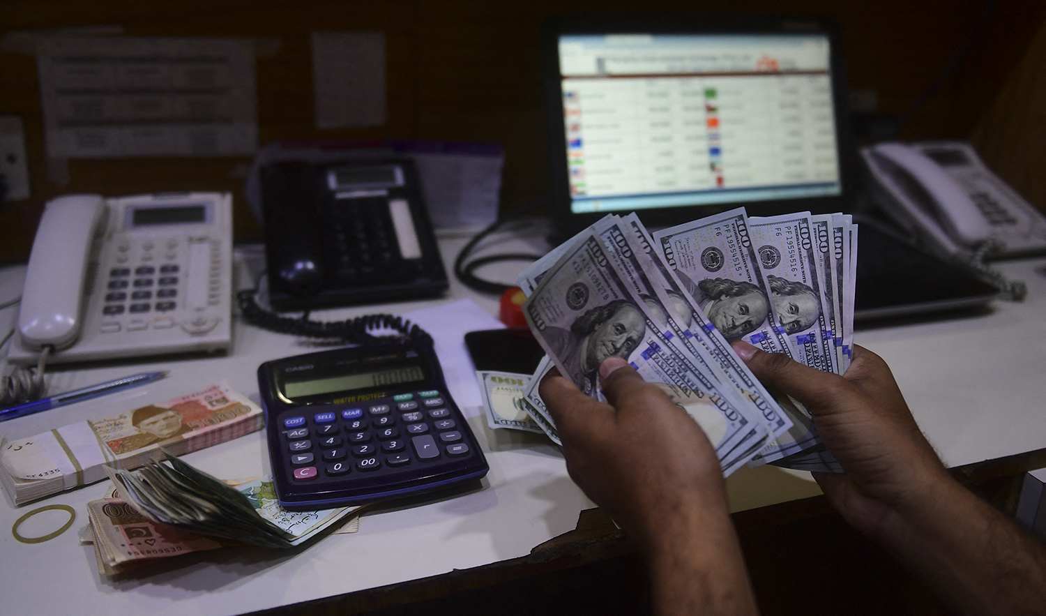 A dealer counts US dollars at a money exchange market in Karachi, Pakistan, on January 27, 2023. (AFP/File)