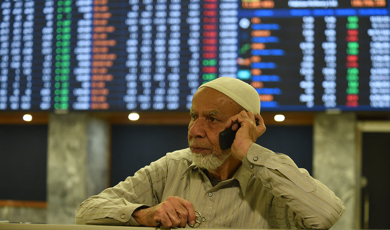A broker talks on a phone as he watches latest share prices at the Pakistan Stock Exchange in Karachi on January 27, 2023. Photo courtesy: AFP)