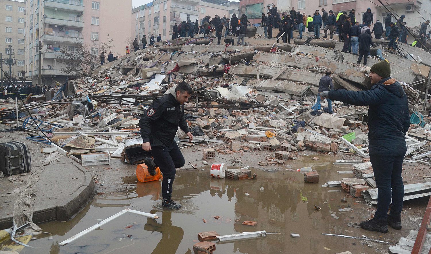 People search for survivors through the rubble in Diyarbakir, on February 6, 2023, after a 7.8-magnitude earthquake struck the country's south-east. (AFP)