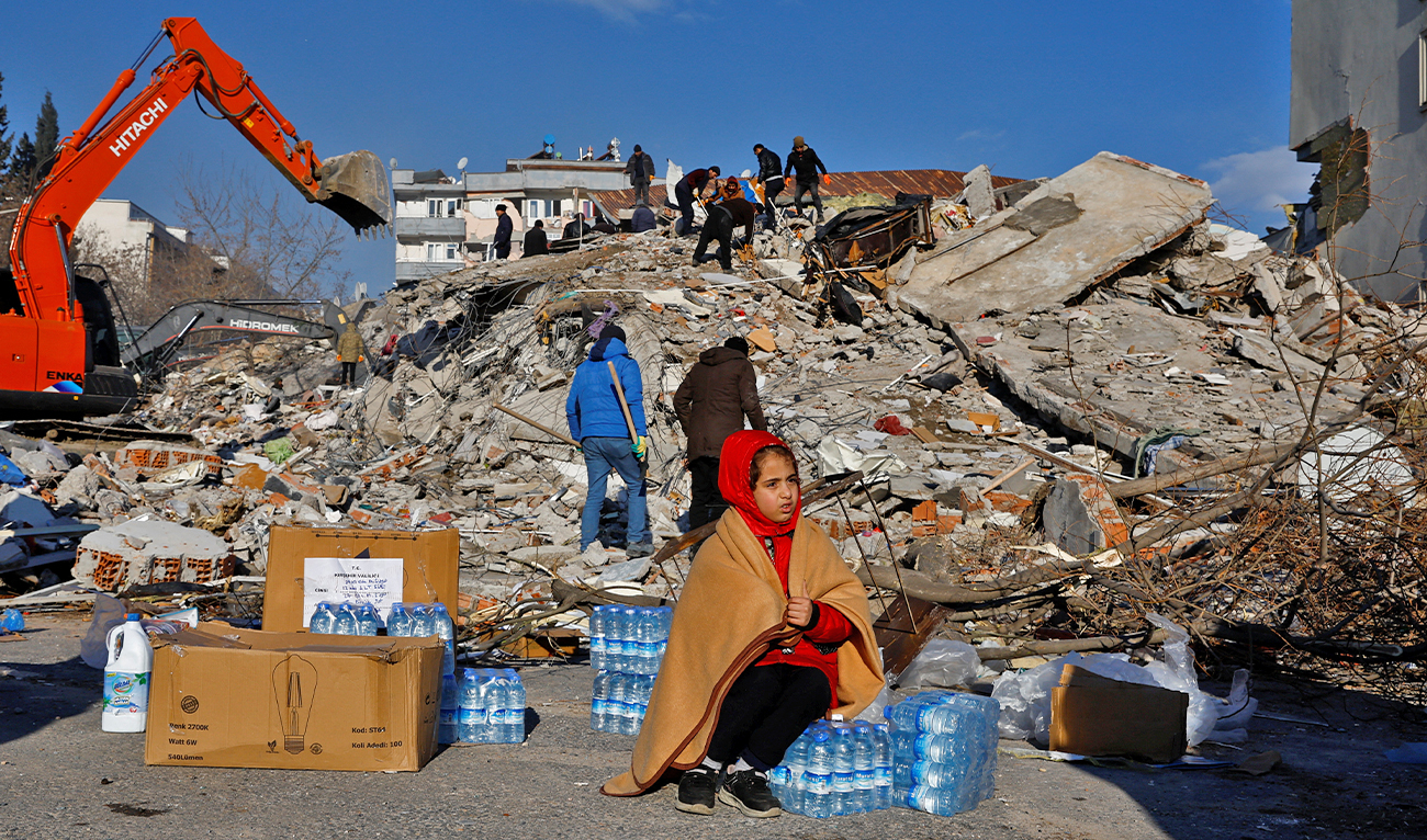 A child is seated amid crates of water in the aftermath of a deadly earthquake in Kahramanmaras, Turkey, on February 8, 2023. (REUTERS)