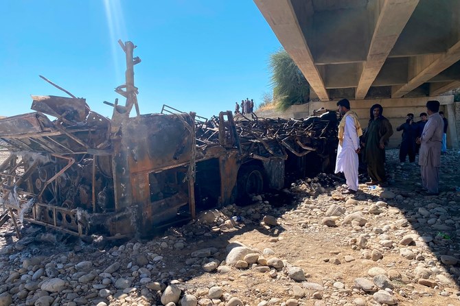 People look at the burnt wreckage of a bus after an accident in Bela, Lasbela, Balochistan, Pakistan, on January 29, 2023. (AP)