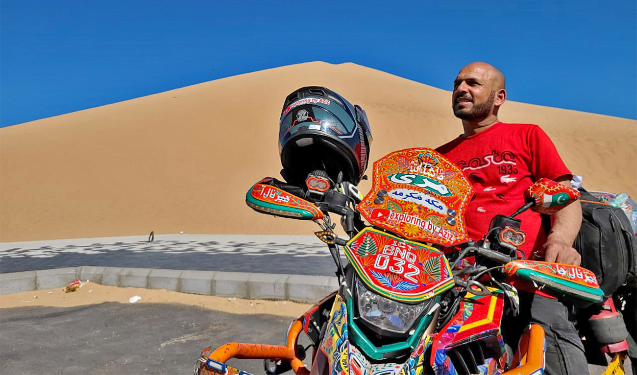 Pakistani biker, Aziz ul Hassan Hashmi (left) poses for picture with his bike painted with truck art at Jabal Al-Malaika in Badr, Saudi Arabia, on February 2, 2023. (Photo courtesy: Aziz ul Hassan Hashmi)