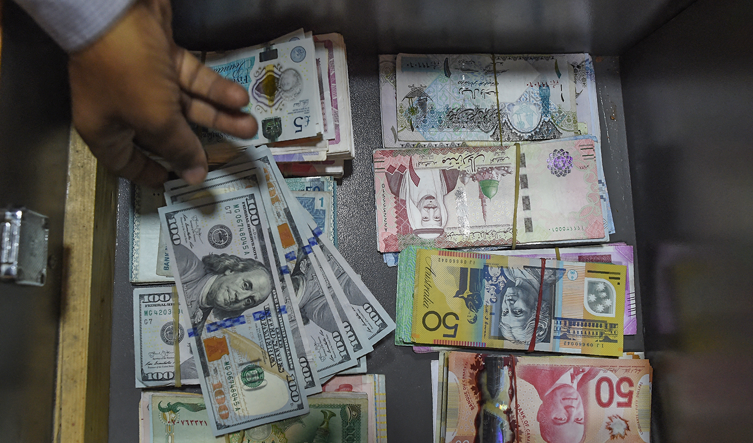 A Pakistani dealer counts US dollars at a currency exchange shop in Karachi on November 30, 2018. (AFP/File)
