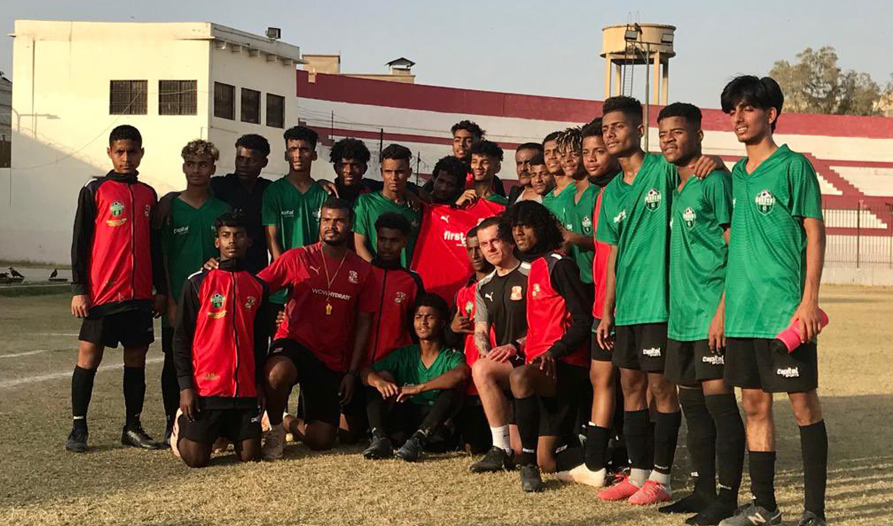 Swindon Town FC coach Alex Pike takes a group photo with football players from Kyari in Saber Sports Academy, Karachi, Pakistan on February 6, 2023. (Photo courtesy: @ukinpakistan/twitter)
