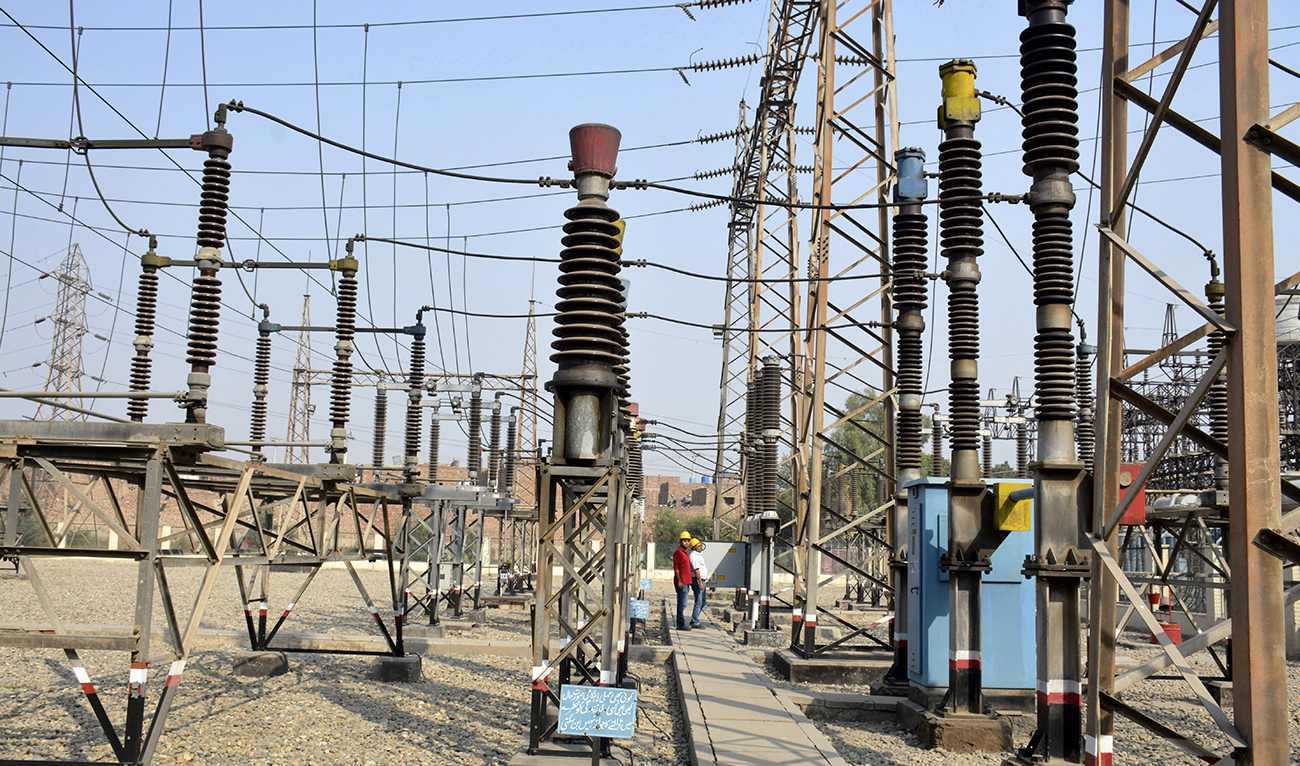 In this photograph taken on November 16, 2016, Pakistani technicians work at a power grid station in Faisalabad. (AFP/FILE)