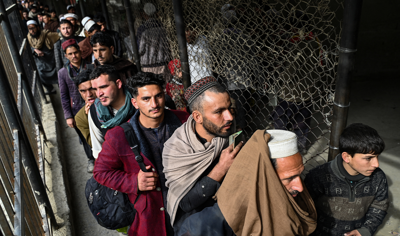 n this picture taken on February 2, 2023, Afghan men stand in queue inside a fenced corridor as they wait to cross into Pakistan at the zero point Torkham border crossing between Afghanistan and Pakistan, in Nangarhar province. (AFP/File)
