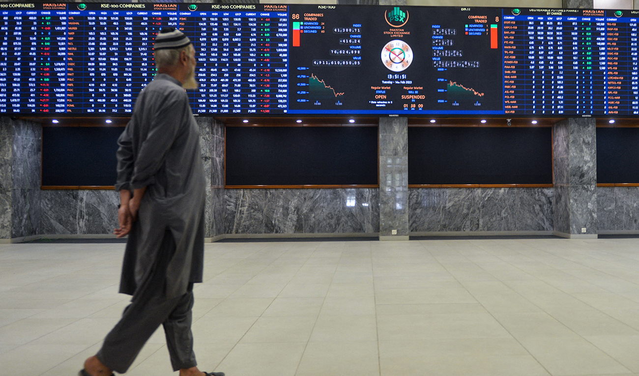 A broker looks at an index board showing the latests share prices at the Pakistan Stock Exchange in Karachi on February 14, 2023. (Photo courtesy: AFP)